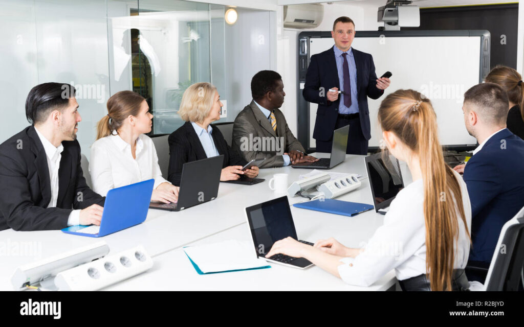Homme d'affaires échangeant avec son équipe autour d'une table de réunion
